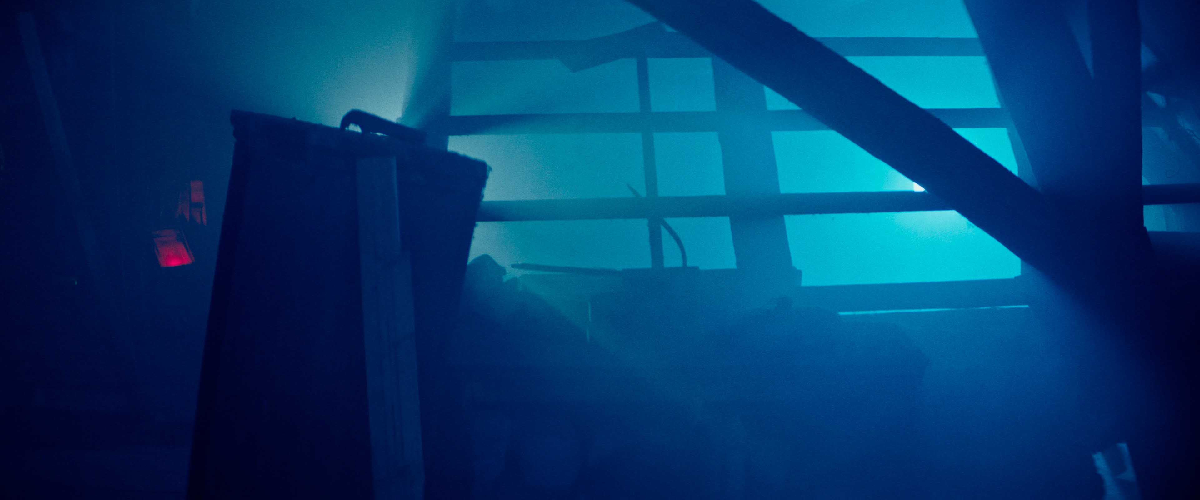 Macro detail: red-lit paddle shifter on a steering wheel, silhouetted against dark blue background.