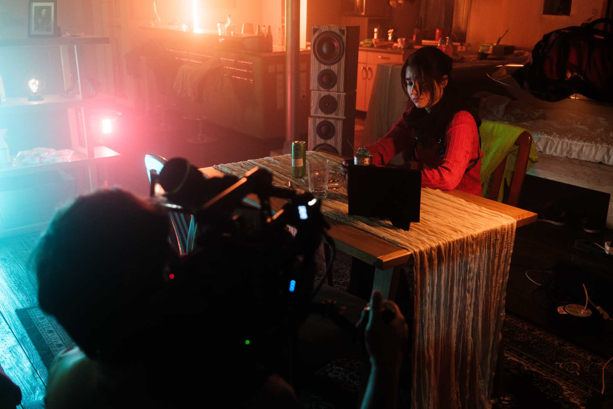 Front-facing Porsche GT3 with headlights on, carving through a chicane at twilight in alpine scenery.