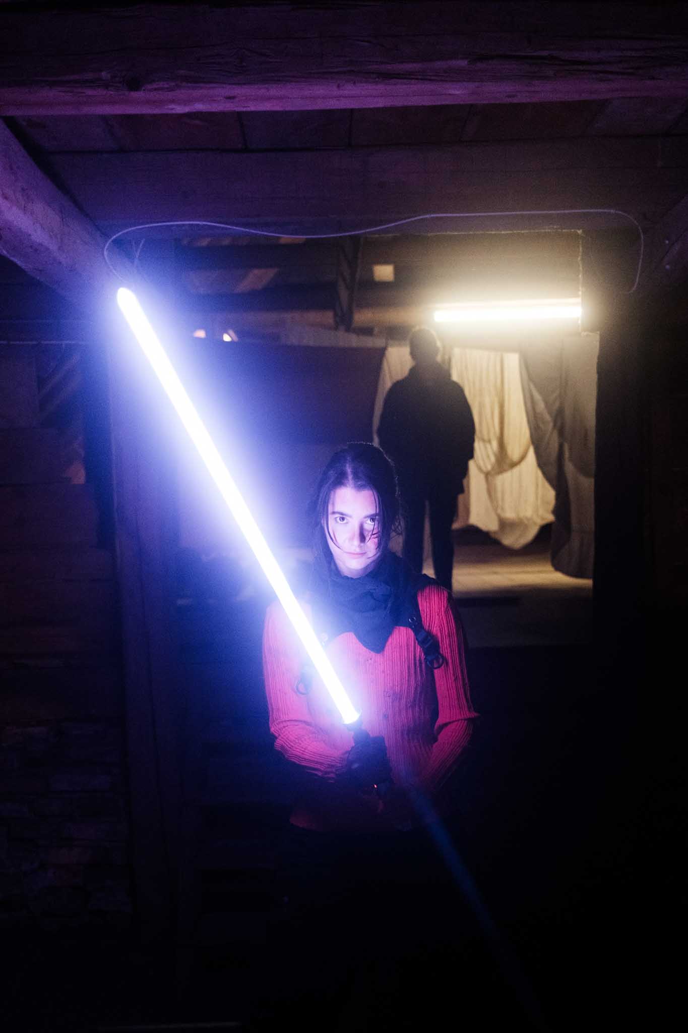 Front-facing Porsche GT3 with headlights on, carving through a chicane at twilight in alpine scenery.