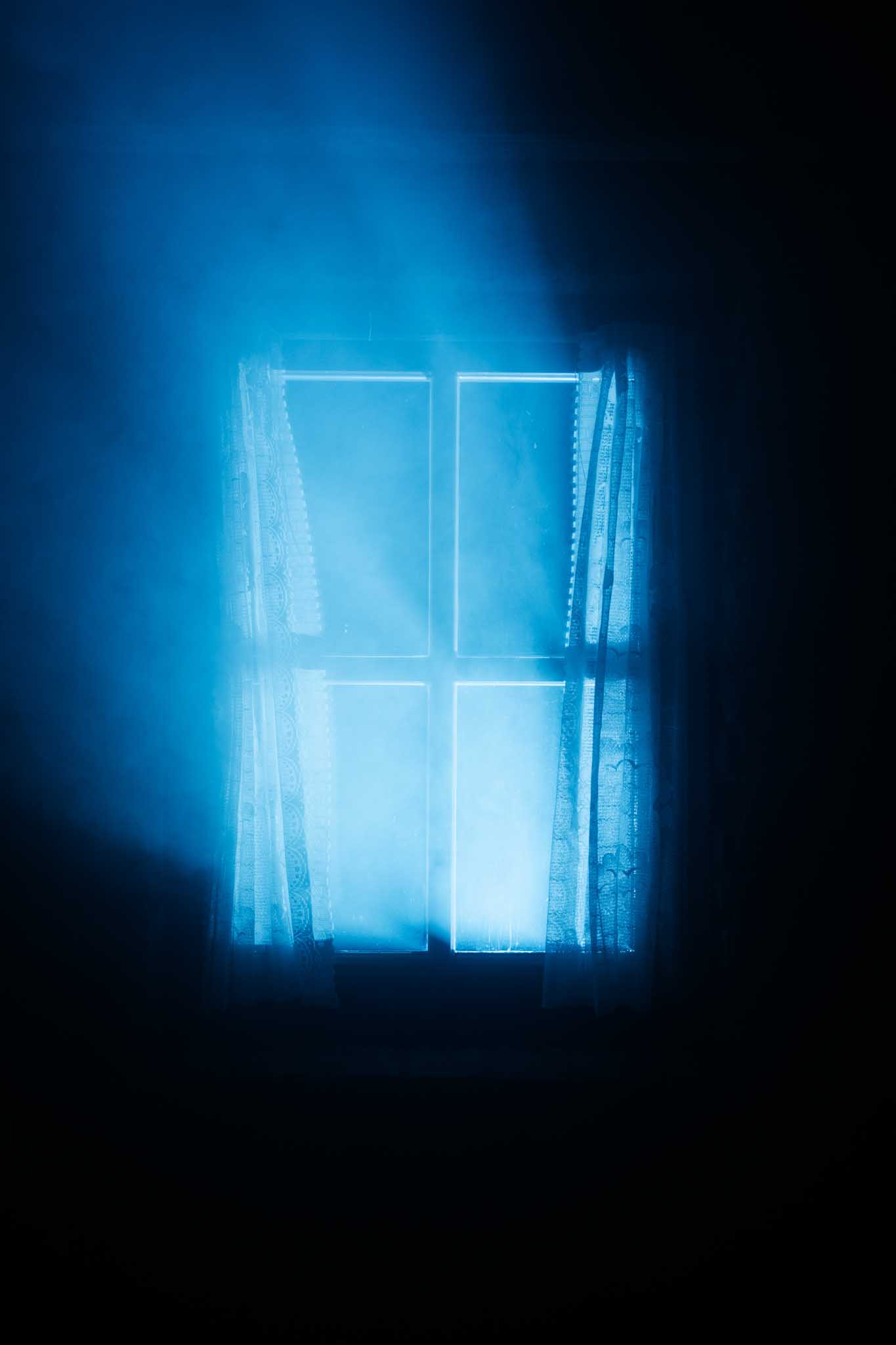 Front-facing Porsche GT3 with headlights on, carving through a chicane at twilight in alpine scenery.