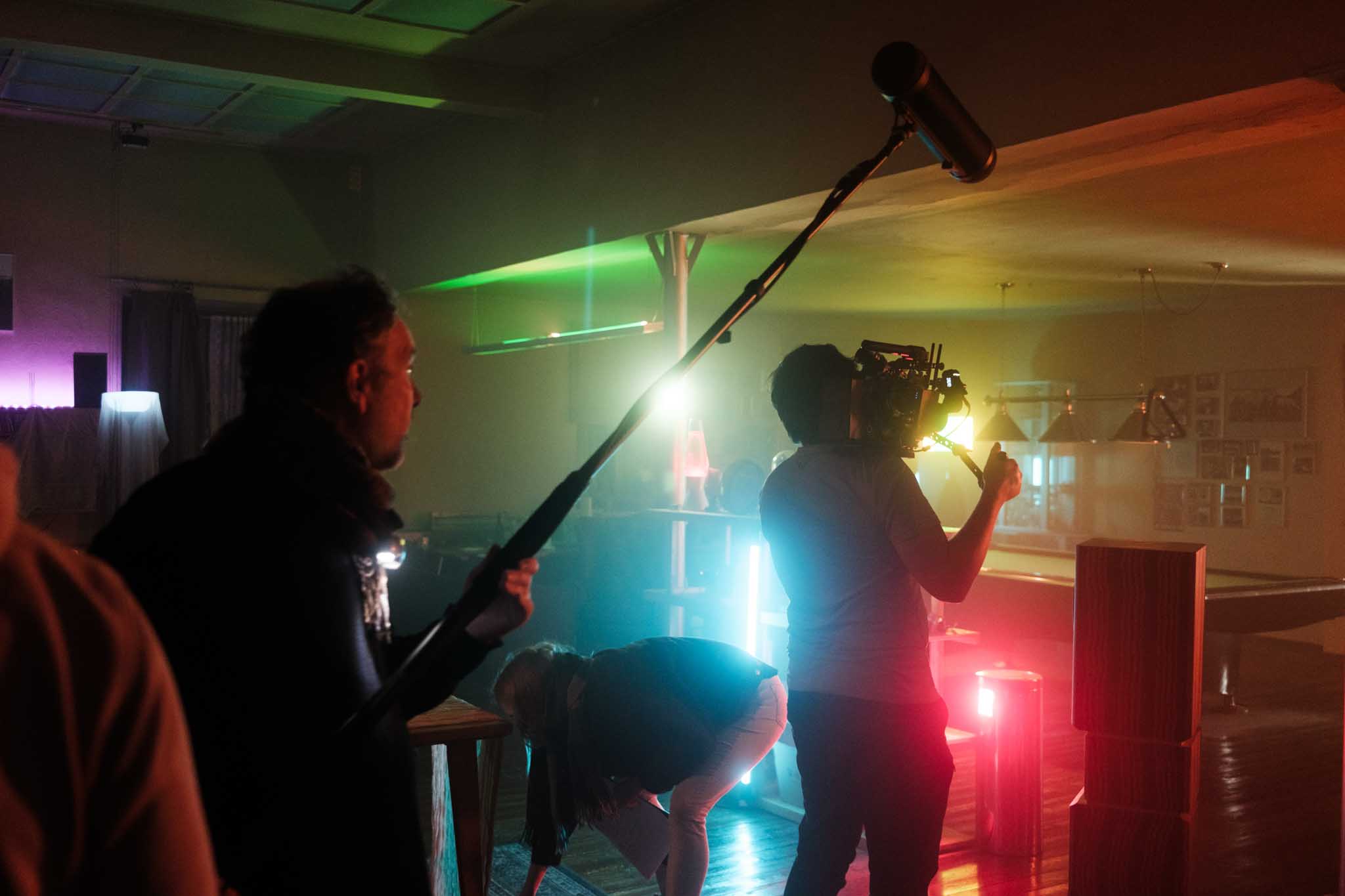 Silhouette of a helmeted racing driver at dusk, mountain skyline faintly visible under violet sky.