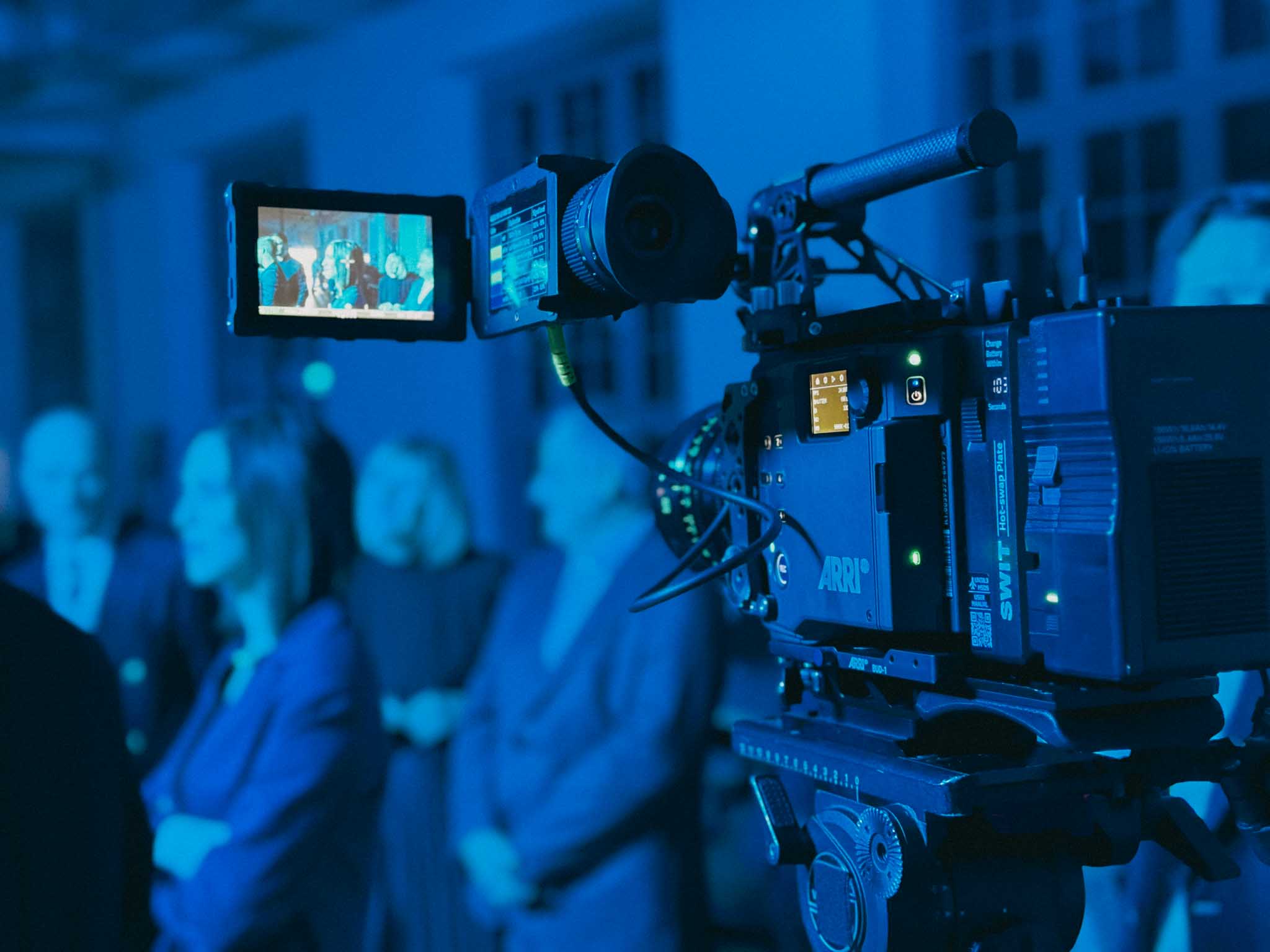 Close-up of a Porsche 911 GT3 rear wing and glowing LED taillight, bathed in deep red tunnel light.