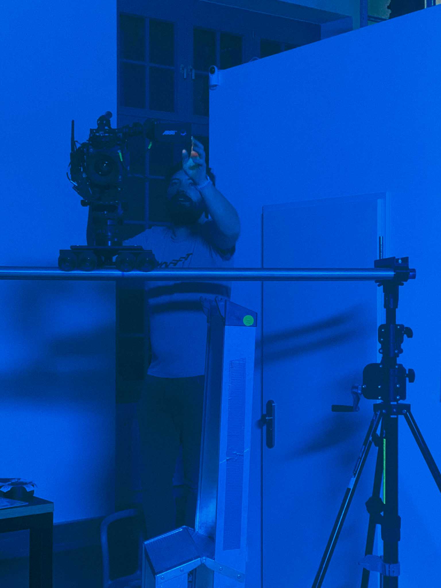Silhouette of a helmeted racing driver at dusk, mountain skyline faintly visible under violet sky.