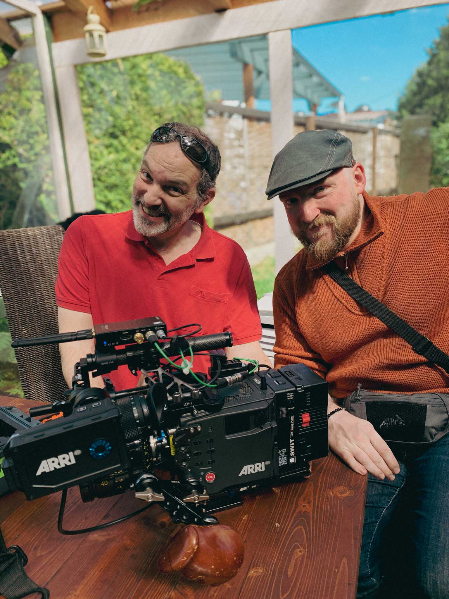 Silver Porsche 911 GT3 racing up a mountain road, motion-blurred asphalt and dramatic cloudscape in the background.