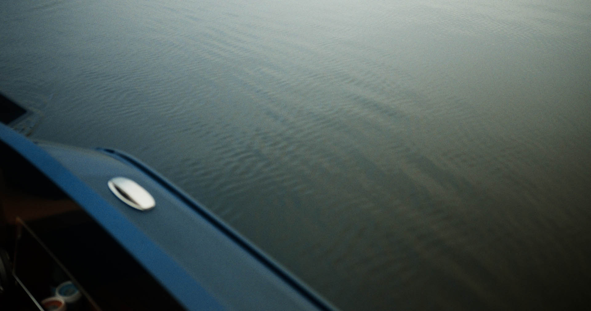 Abstract motion-blur of red and white kerb stripes on dark asphalt, evoking racetrack speed.
