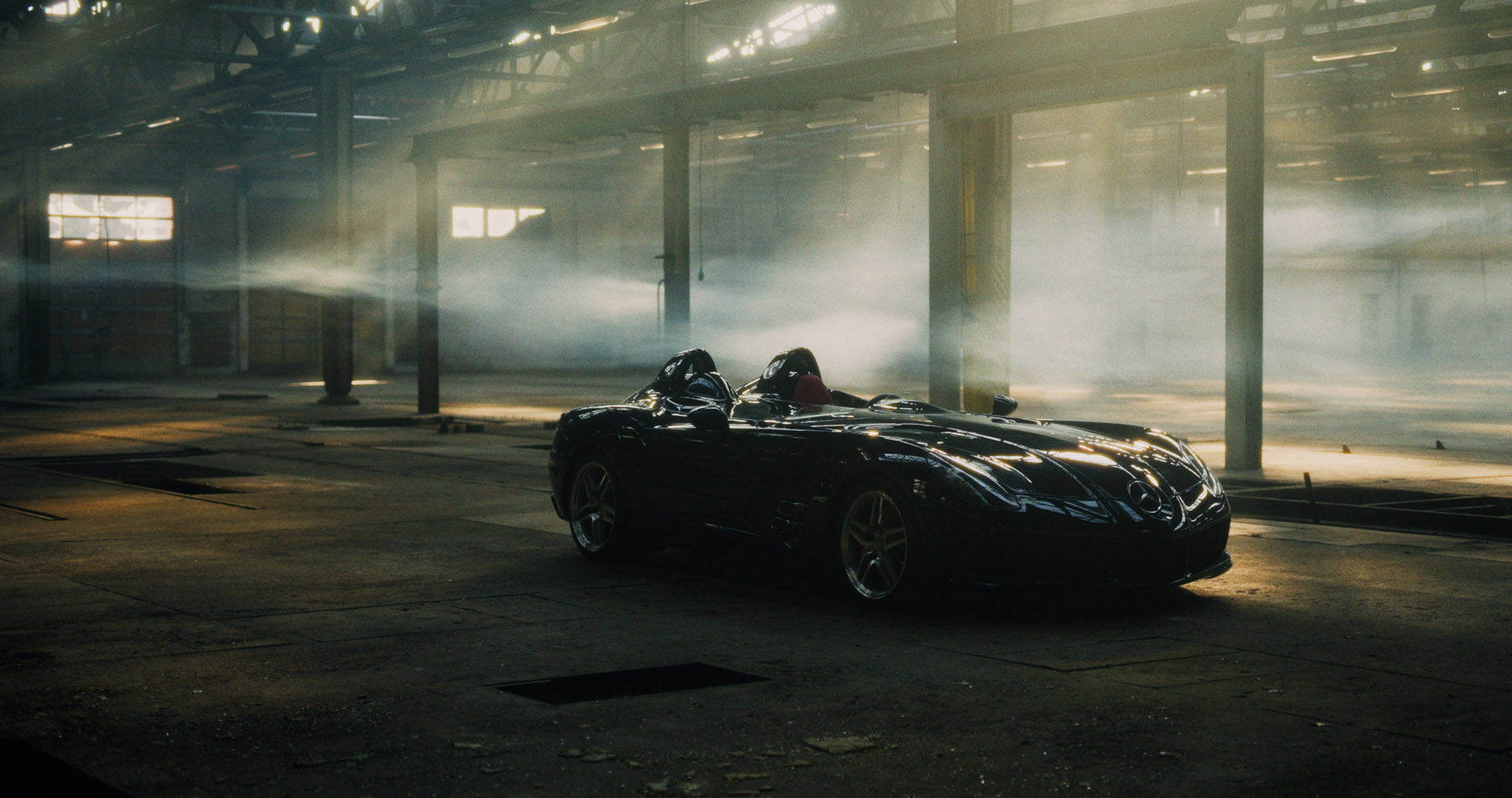 Macro detail: red-lit paddle shifter on a steering wheel, silhouetted against dark blue background.