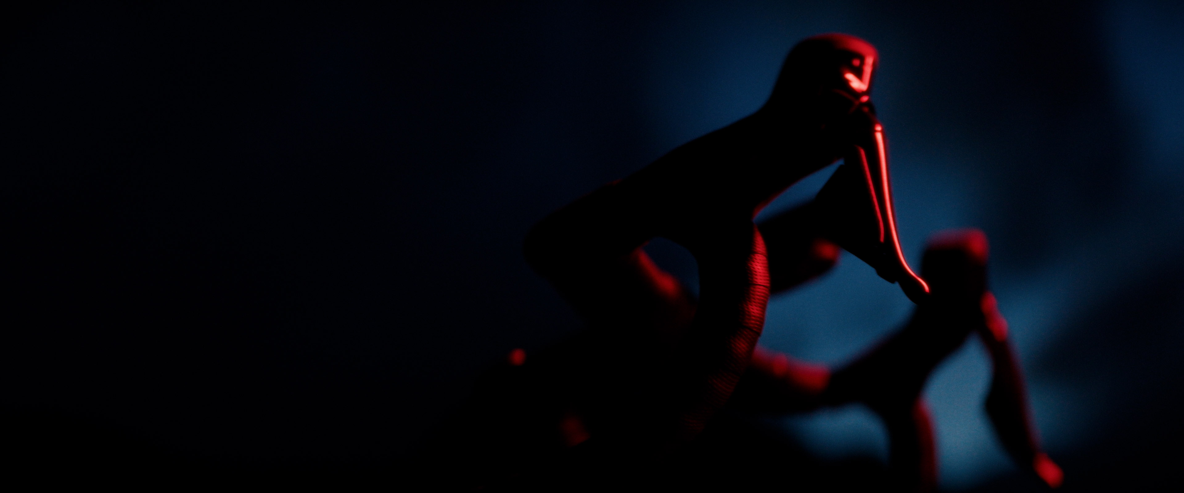 Macro detail: red-lit paddle shifter on a steering wheel, silhouetted against dark blue background.
