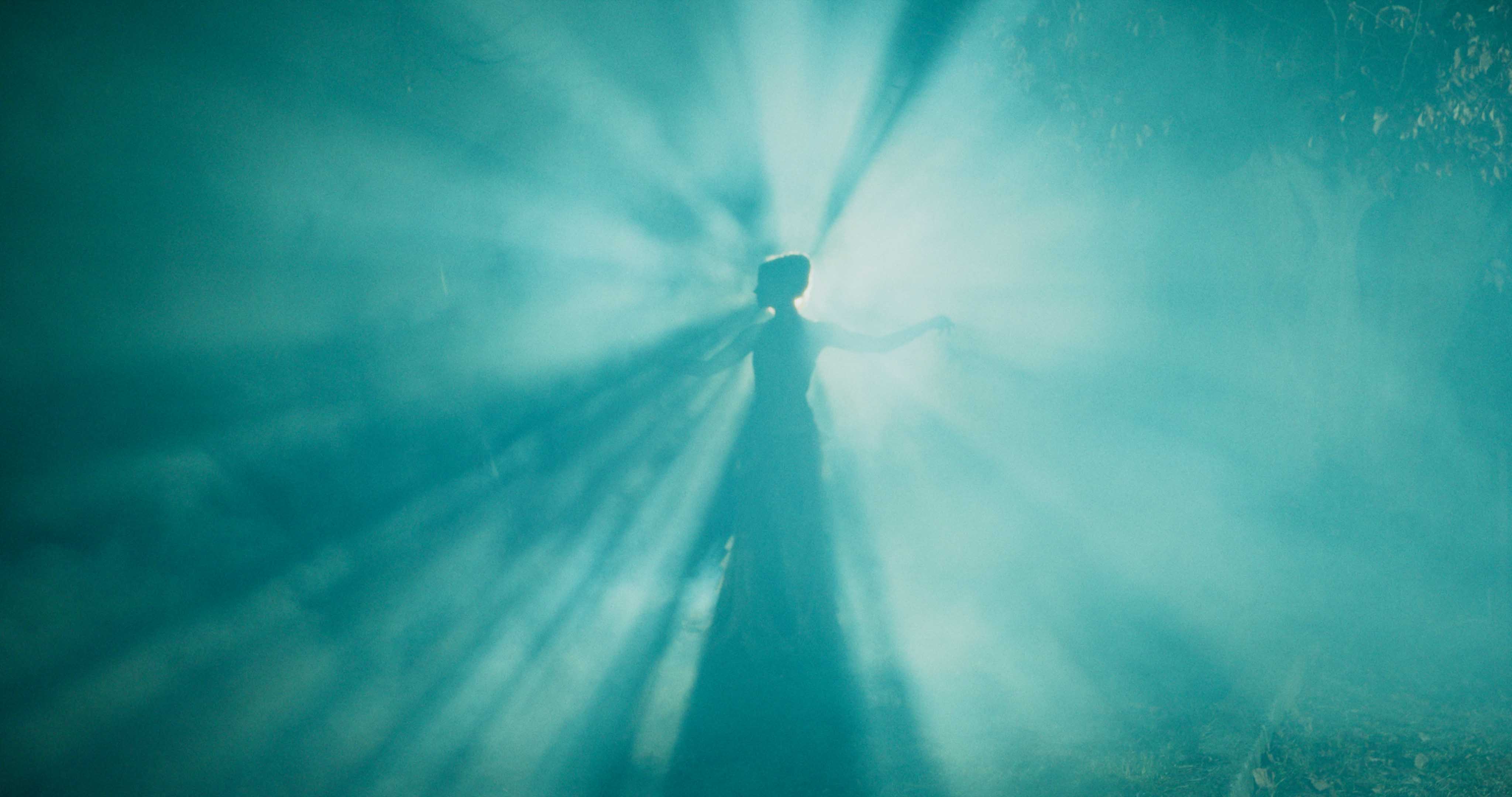 Silver Porsche 911 GT3 racing up a mountain road, motion-blurred asphalt and dramatic cloudscape in the background.